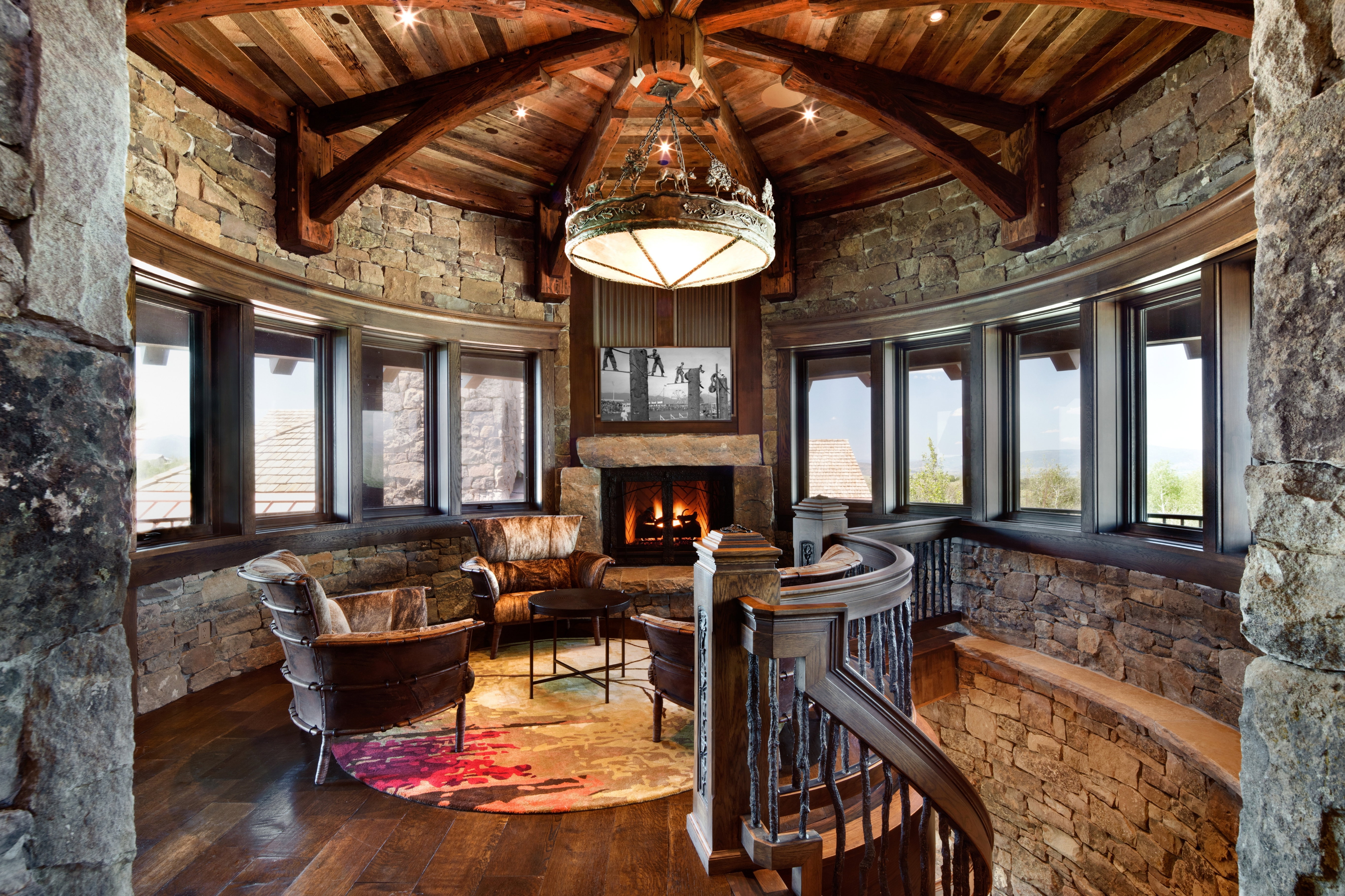 Sitting room featuring wood-type flooring, a high wood beamed ceiling, and a fireplace