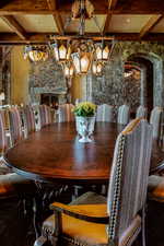 Dining room featuring a stone fireplace and coffered ceiling