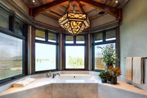 Bathroom featuring a bath and a wooden ceiling with exposed beams
