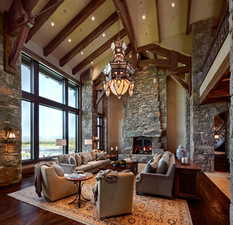 Living room featuring a fireplace, suspended lighting, hardwood / wood-style floors, and lofted ceiling