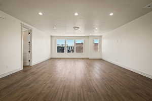 Spare room featuring dark wood-type flooring and recessed lighting