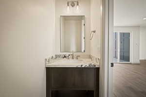 Half bath with vanity and wood finished floors