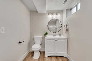 Bathroom featuring vanity, a textured ceiling, and light wood finished floors