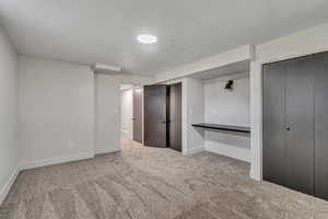 Unfurnished bedroom with baseboards and light colored carpet