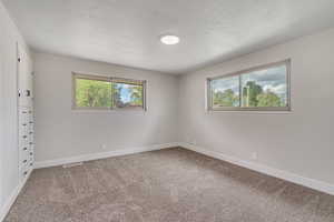 Spare room with light carpet and baseboards
