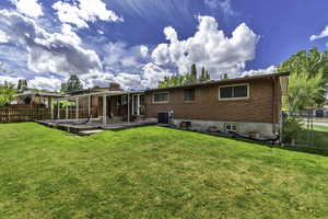 Back of property with a fenced backyard, brick siding, a gate, and a chimney