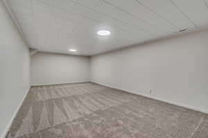 Finished below grade area with baseboards and light colored carpet