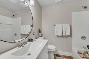 Bathroom with vanity, shower / washtub combination, and wood finished floors