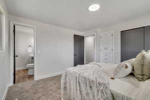 Carpeted bedroom with baseboards and a closet