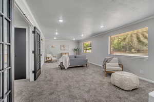 Carpeted bedroom with ornamental molding and french doors
