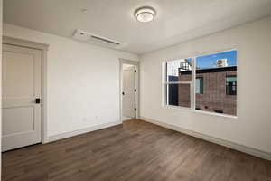 Spare room with dark wood finished floors and a textured ceiling