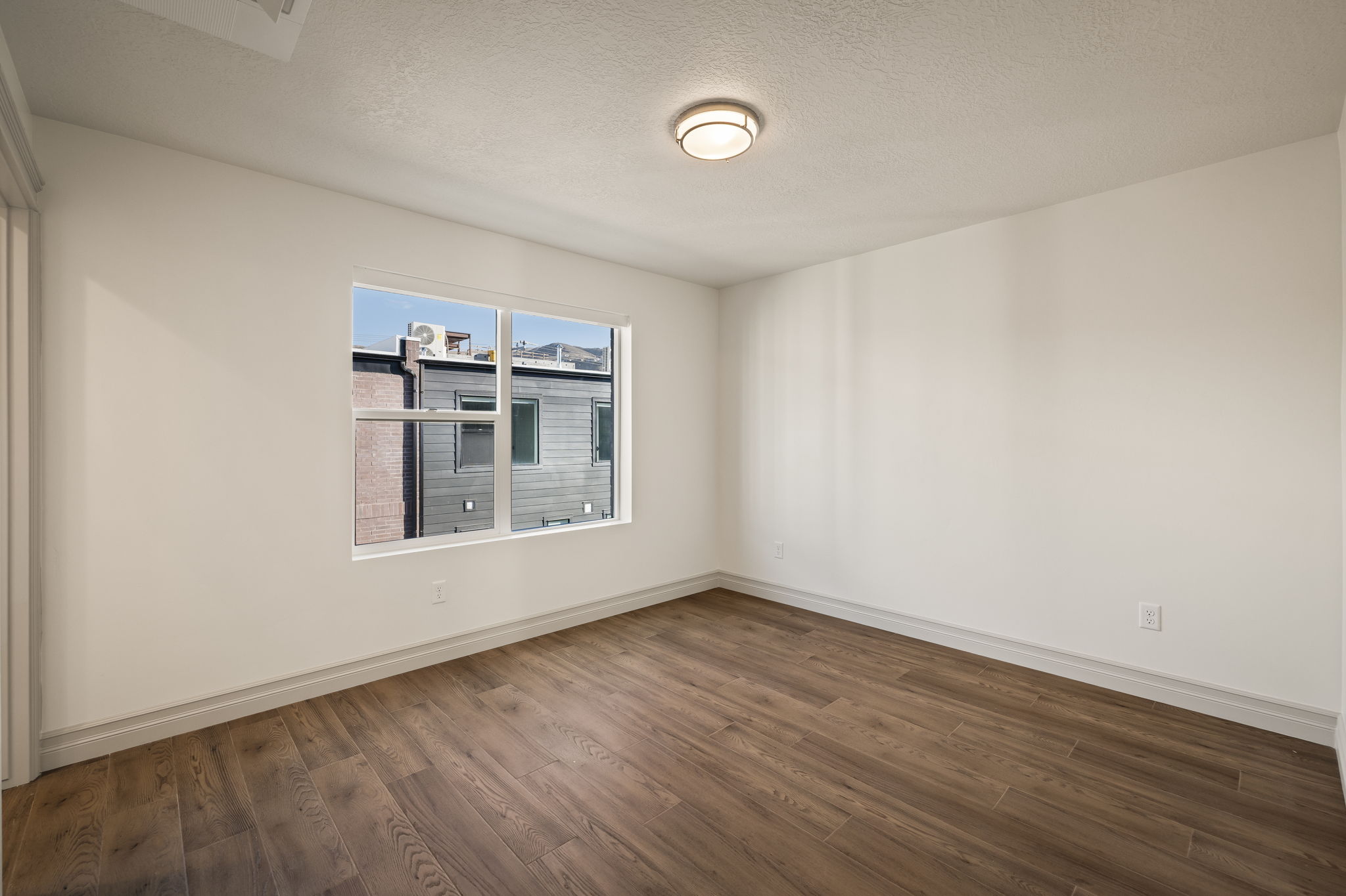 Empty room featuring dark wood-style flooring and a textured ceiling