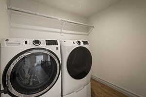 Laundry area with dark wood-type flooring and separate washer and dryer