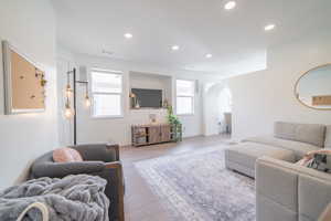 Living room featuring wood finished floors, arched walkways, and recessed lighting