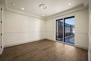 Spare room with dark wood-type flooring, a textured ceiling, and recessed lighting