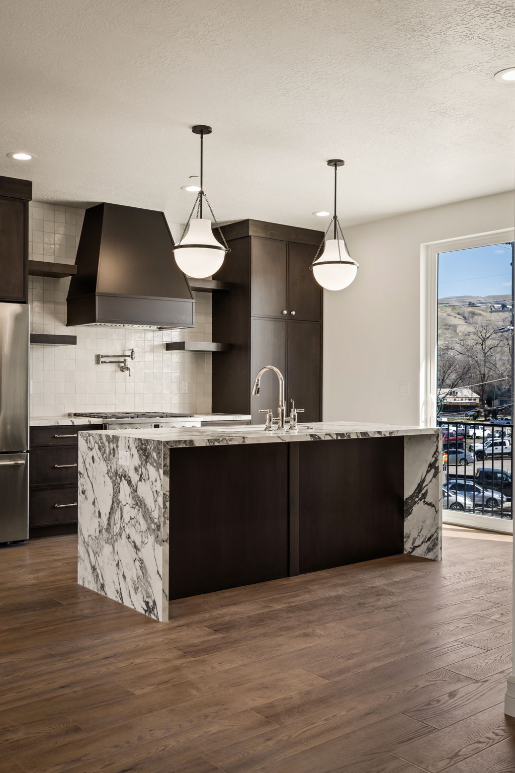 Kitchen featuring dark wood finish cabinetry, light stone countertops, and dark wood finished floors