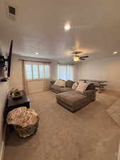 Living area featuring recessed lighting, light colored carpet, ceiling fan, healthy amount of natural light, and a textured ceiling