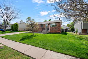 View of front of property featuring brick siding and a chimney