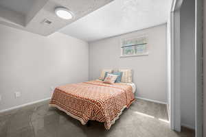 Bedroom featuring carpet floors and a textured ceiling