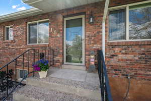 View of exterior entry with brick siding