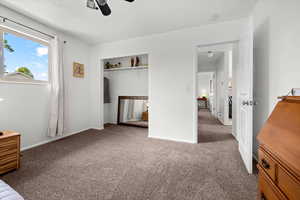 Unfurnished bedroom with a closet, dark colored carpet, ceiling fan, and a textured ceiling