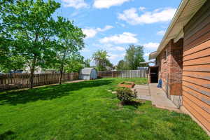 Fenced backyard with a patio area and a shed