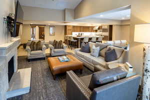 Living room with a high ceiling, recessed lighting, and a fireplace with raised hearth