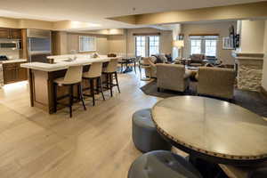 Dining area featuring light wood-style floors and a fireplace