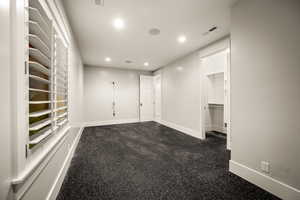 Empty room featuring dark carpet and recessed lighting