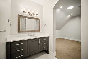 Bathroom featuring light carpet, vanity, vaulted ceiling, and recessed lighting