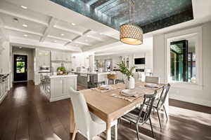 Dining area with coffered ceiling, dark wood-style floors, and recessed lighting