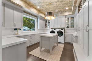 Laundry room with washing machine and dryer, dark wood-style floors, and recessed lighting