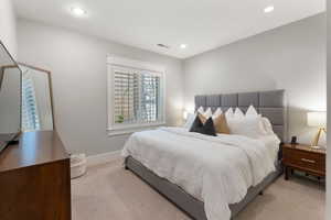 Bedroom with light colored carpet and recessed lighting