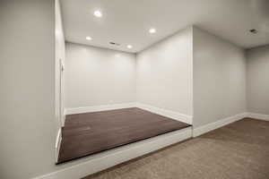 Spare room featuring recessed lighting and dark colored carpet