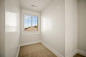 Spare room with light colored carpet and baseboards
