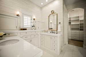 Full bath featuring vanity, a spacious closet, light tile patterned floors, and recessed lighting