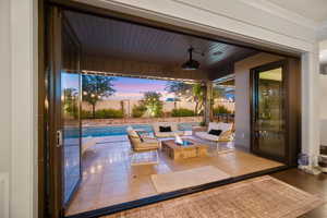 Patio terrace at dusk featuring a patio, an outdoor living space with a fire pit, and a fenced backyard