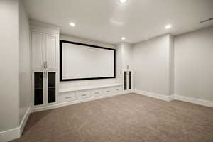 Home theater featuring dark colored carpet and recessed lighting