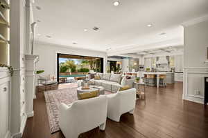 Living area with recessed lighting, dark wood finished floors, crown molding, and coffered ceiling