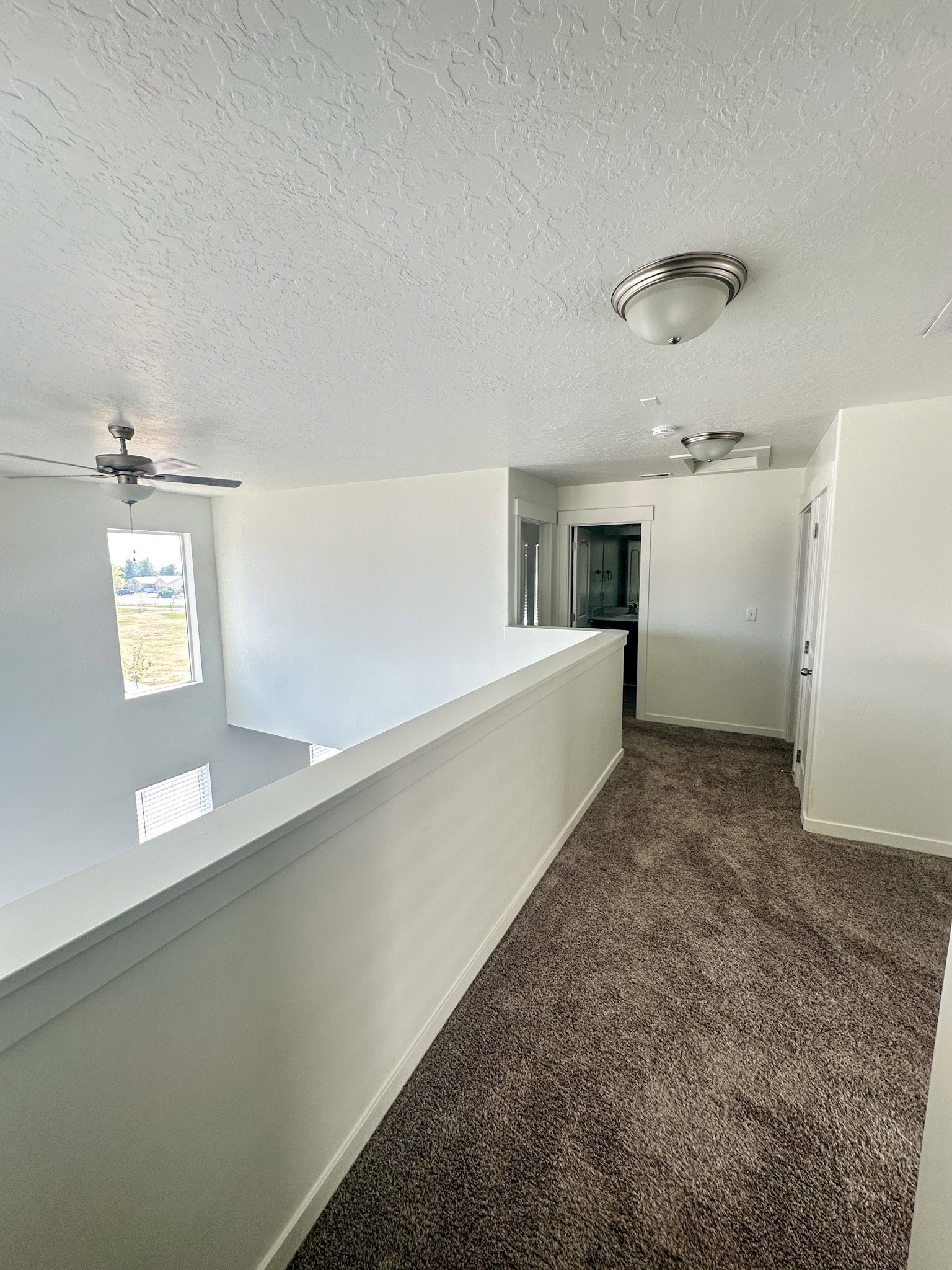 Hallway featuring dark carpet and a textured ceiling
