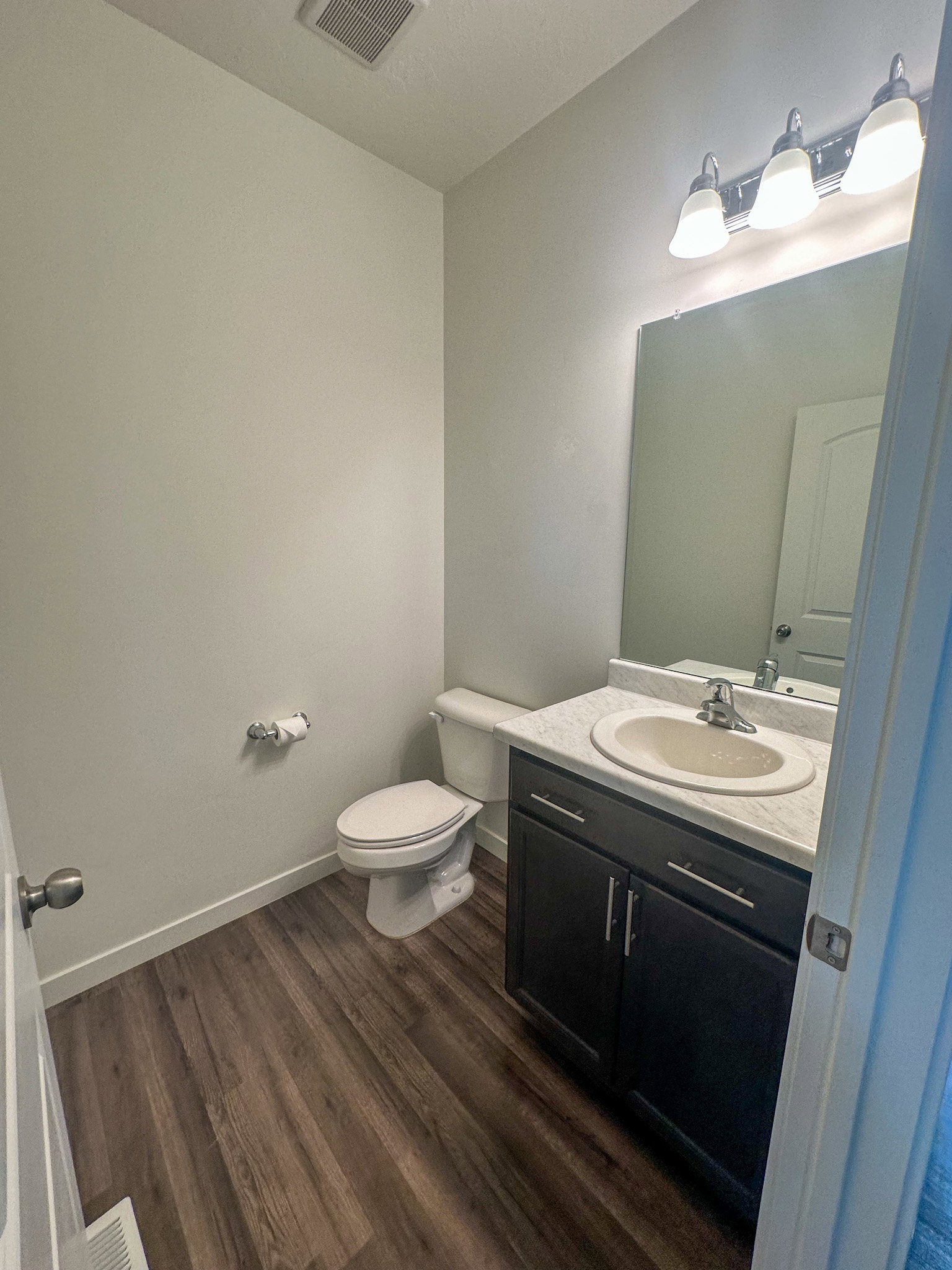 Half bath featuring vanity and dark wood finished floors