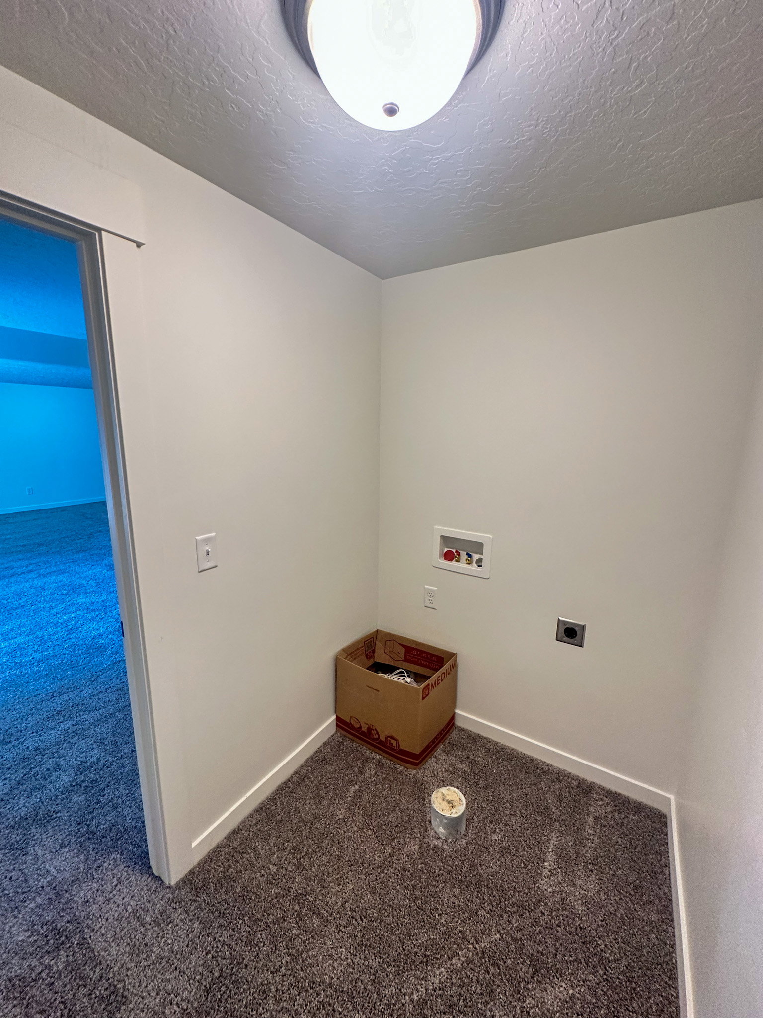 Laundry room featuring dark carpet, washer hookup, a textured ceiling, and electric dryer hookup