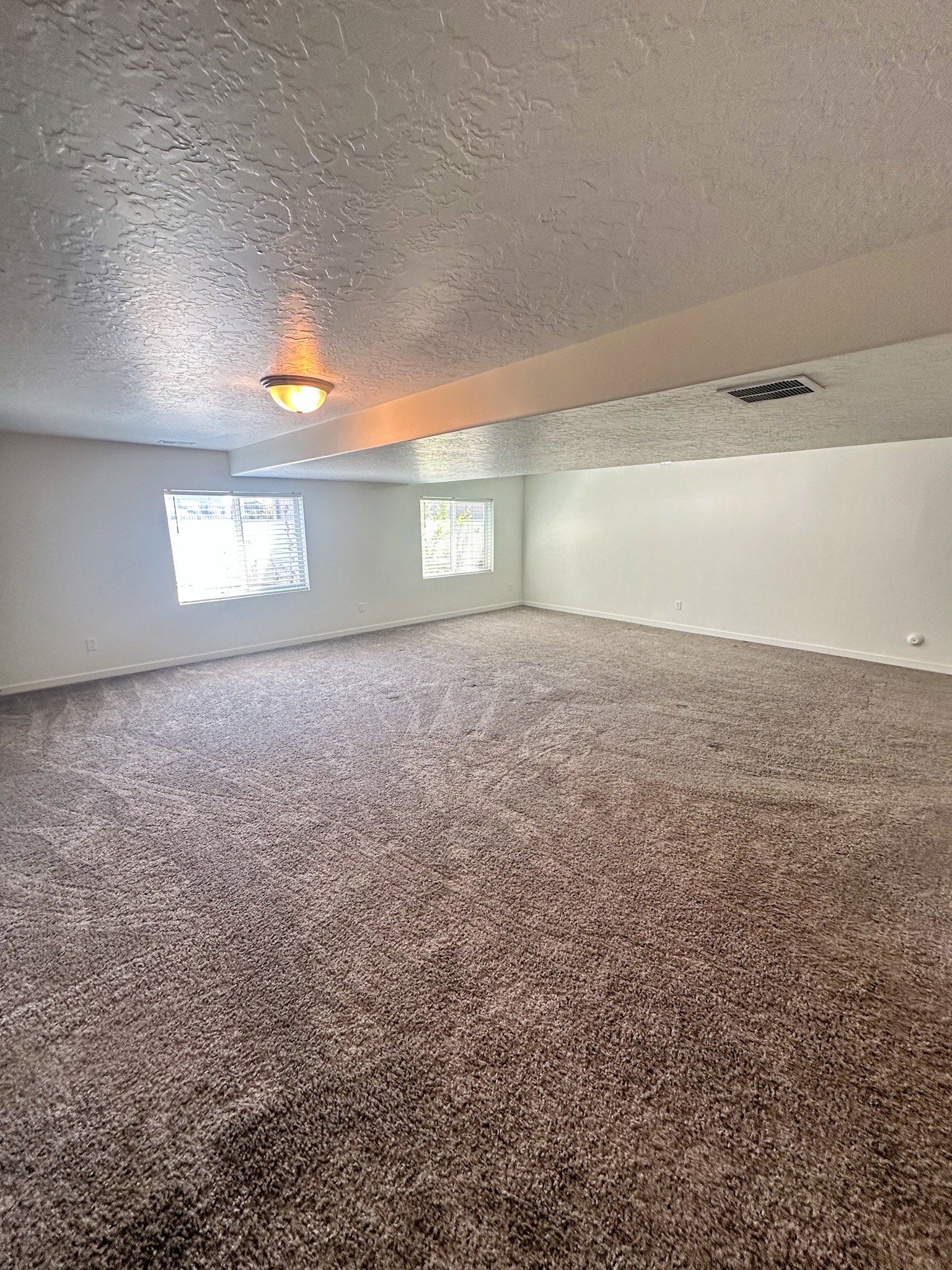Carpeted spare room with baseboards and a textured ceiling