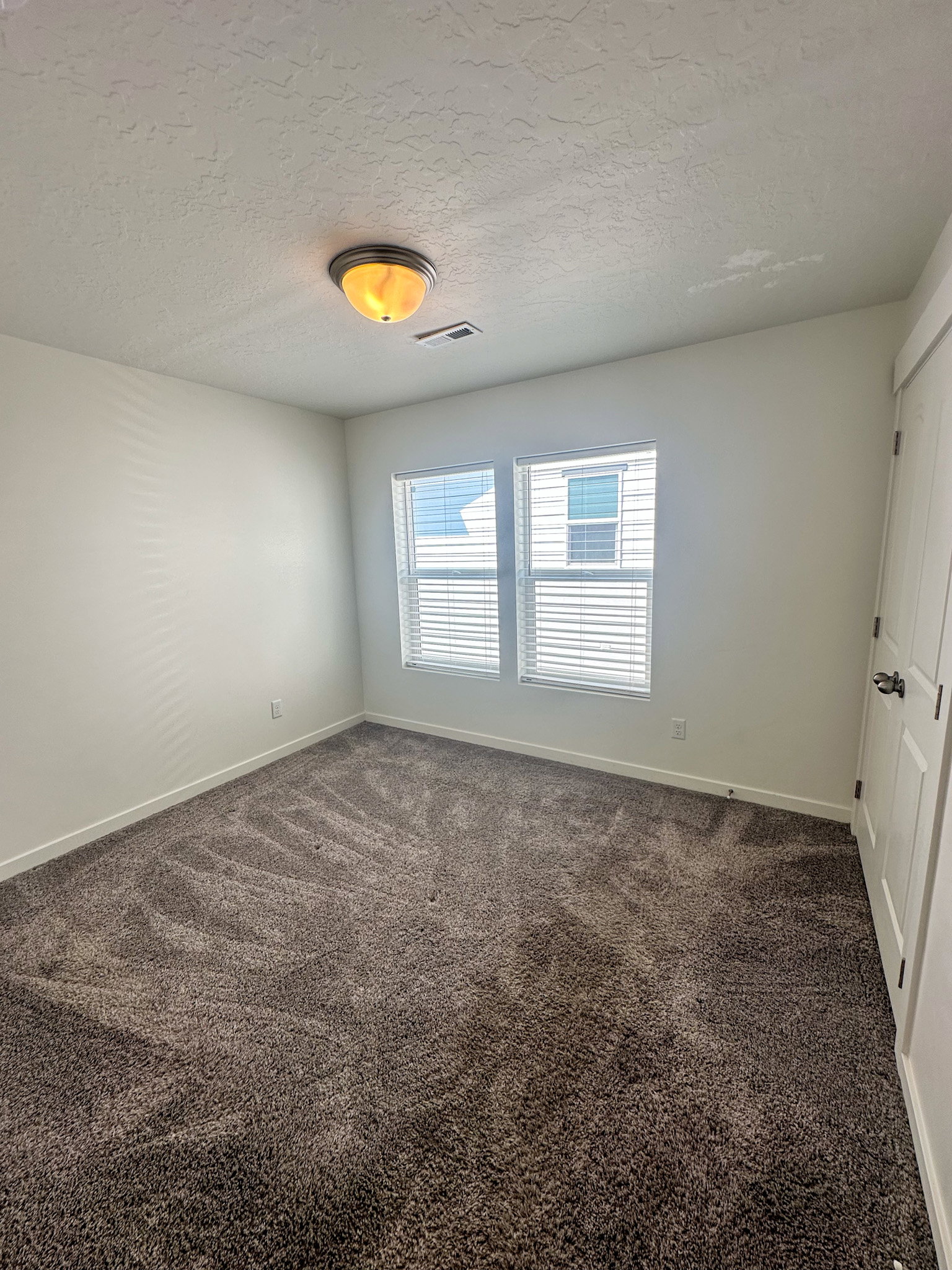 Unfurnished room with dark carpet and a textured ceiling