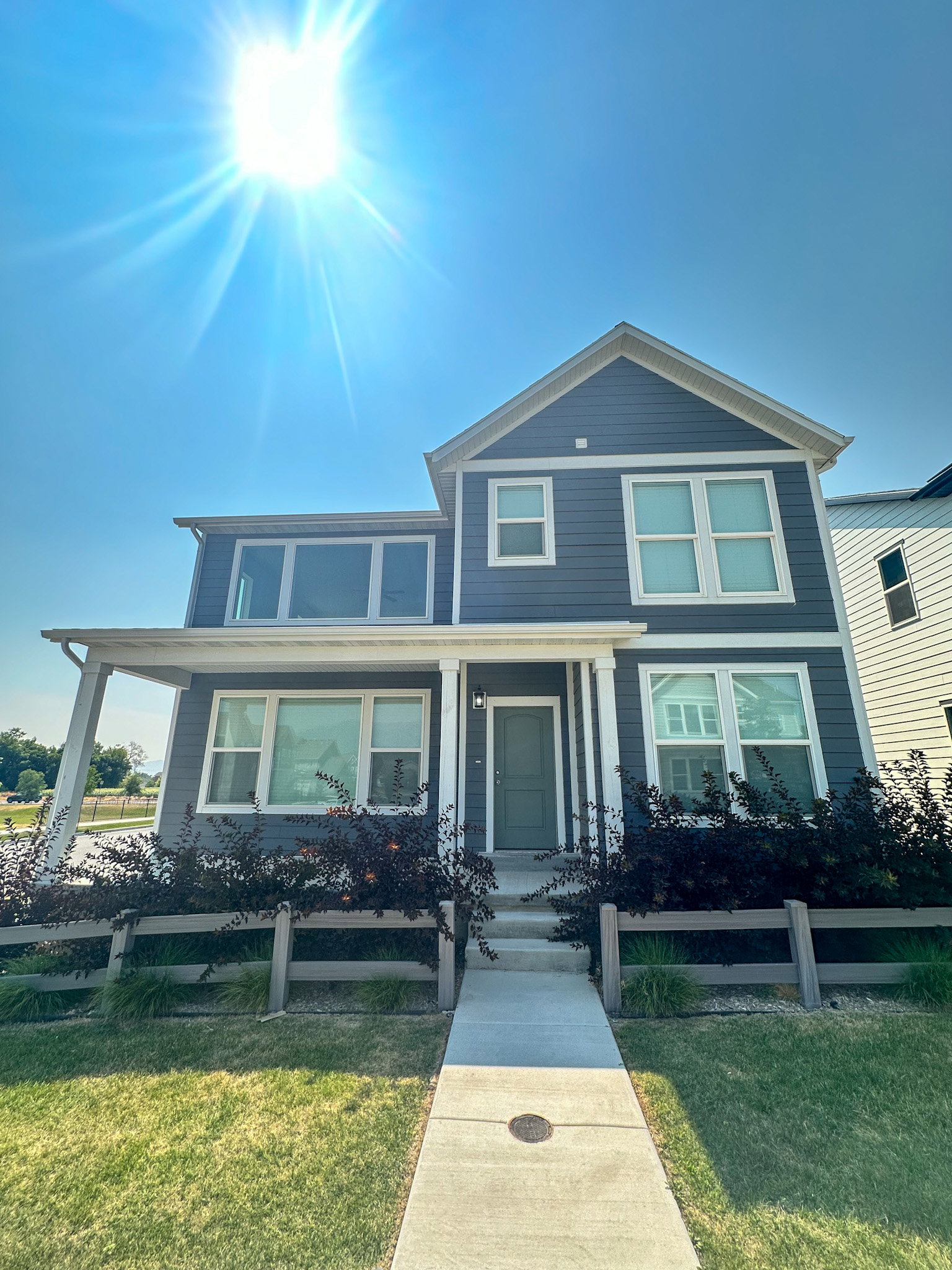View of front facade featuring covered porch and a fenced front yard