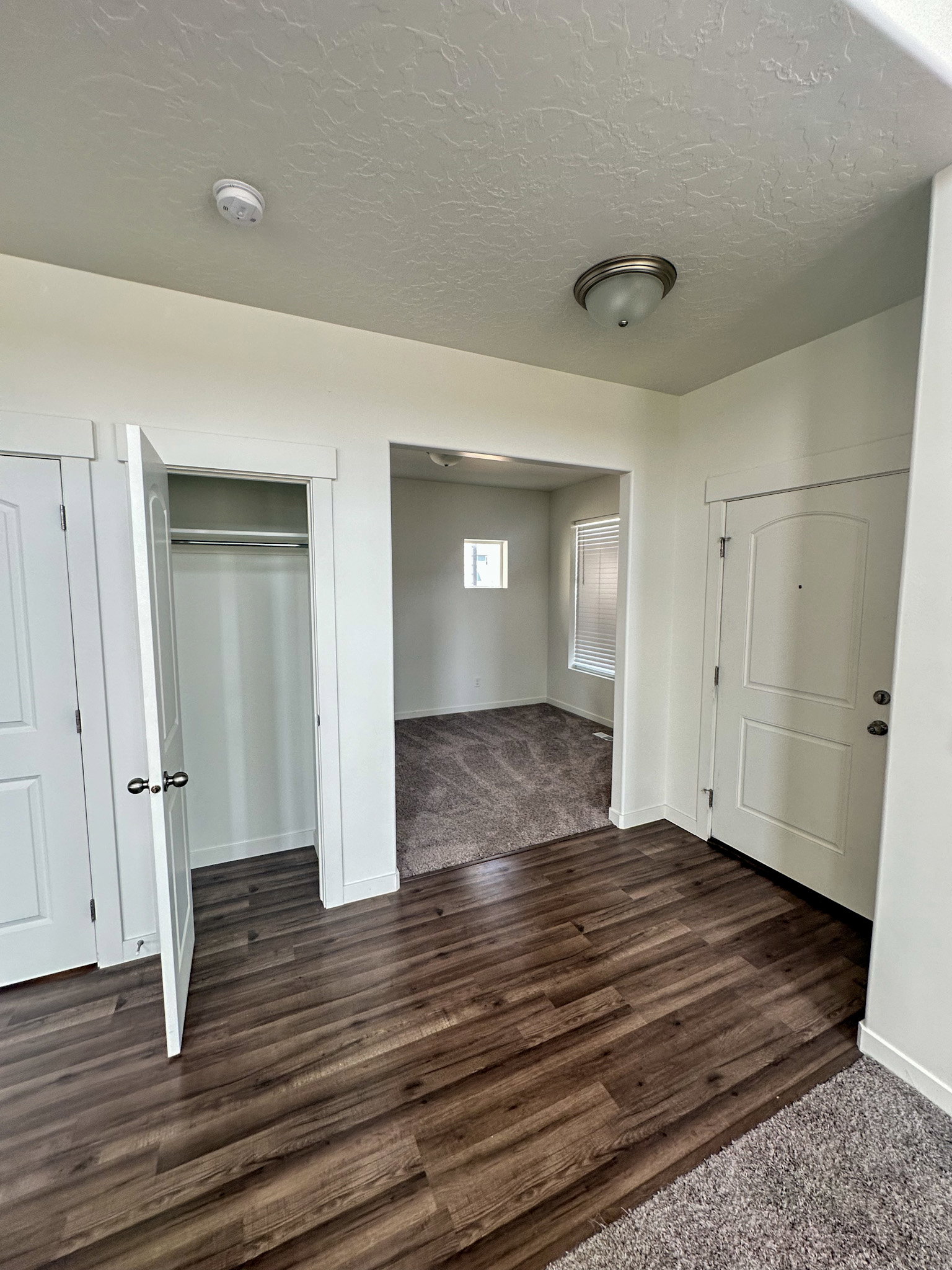 Unfurnished bedroom featuring dark wood finished floors, a closet, and a textured ceiling