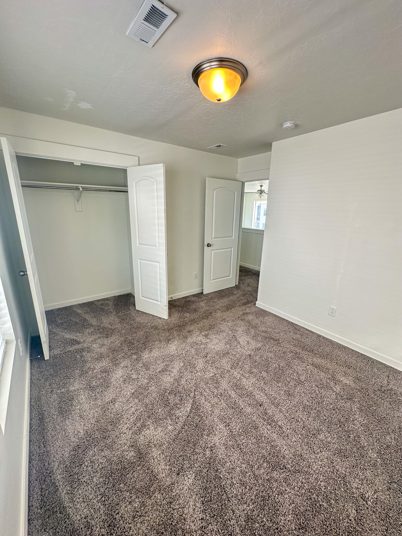 Unfurnished bedroom with a closet, dark carpet, and a textured ceiling