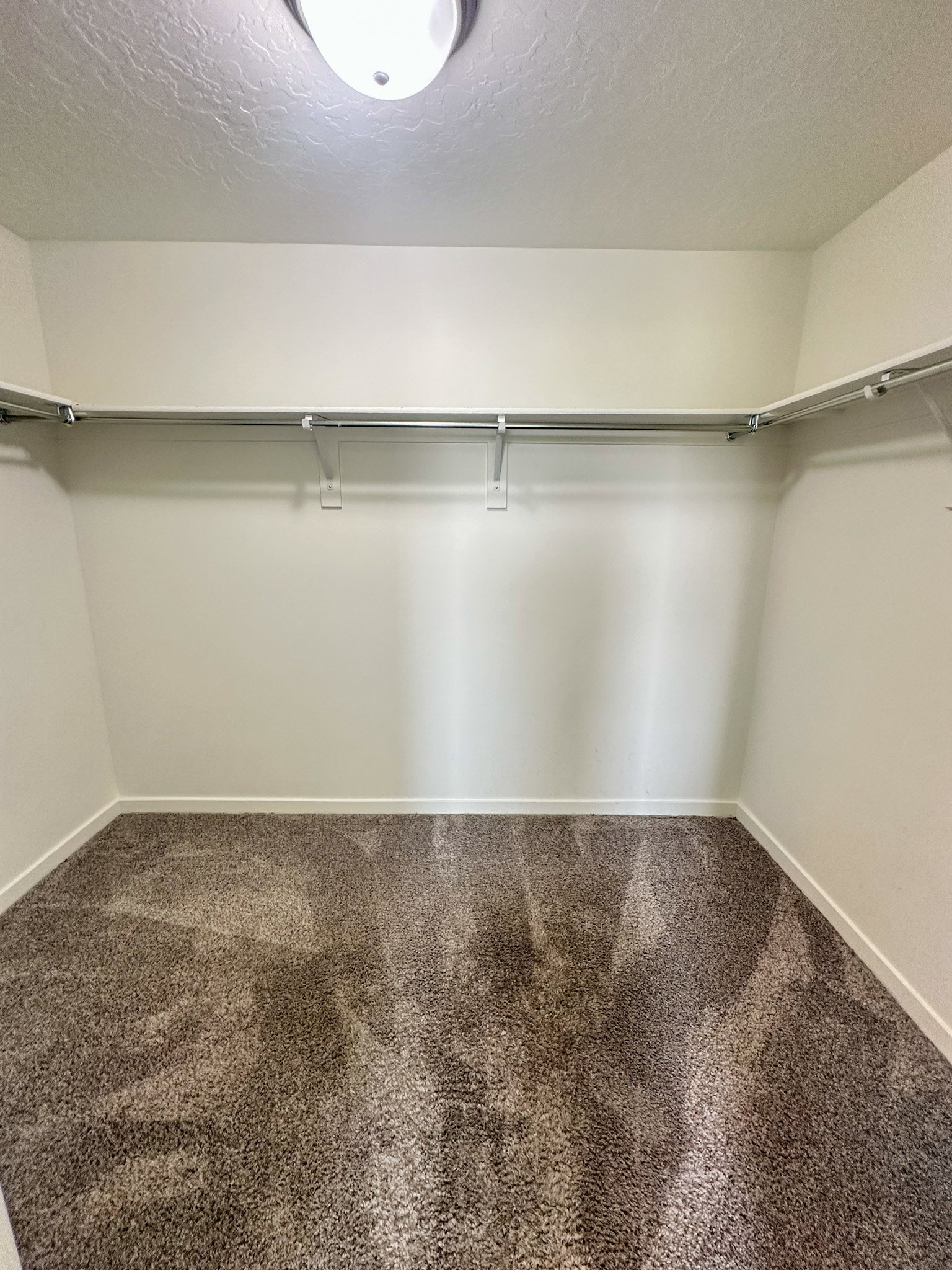 Walk in closet with dark carpet