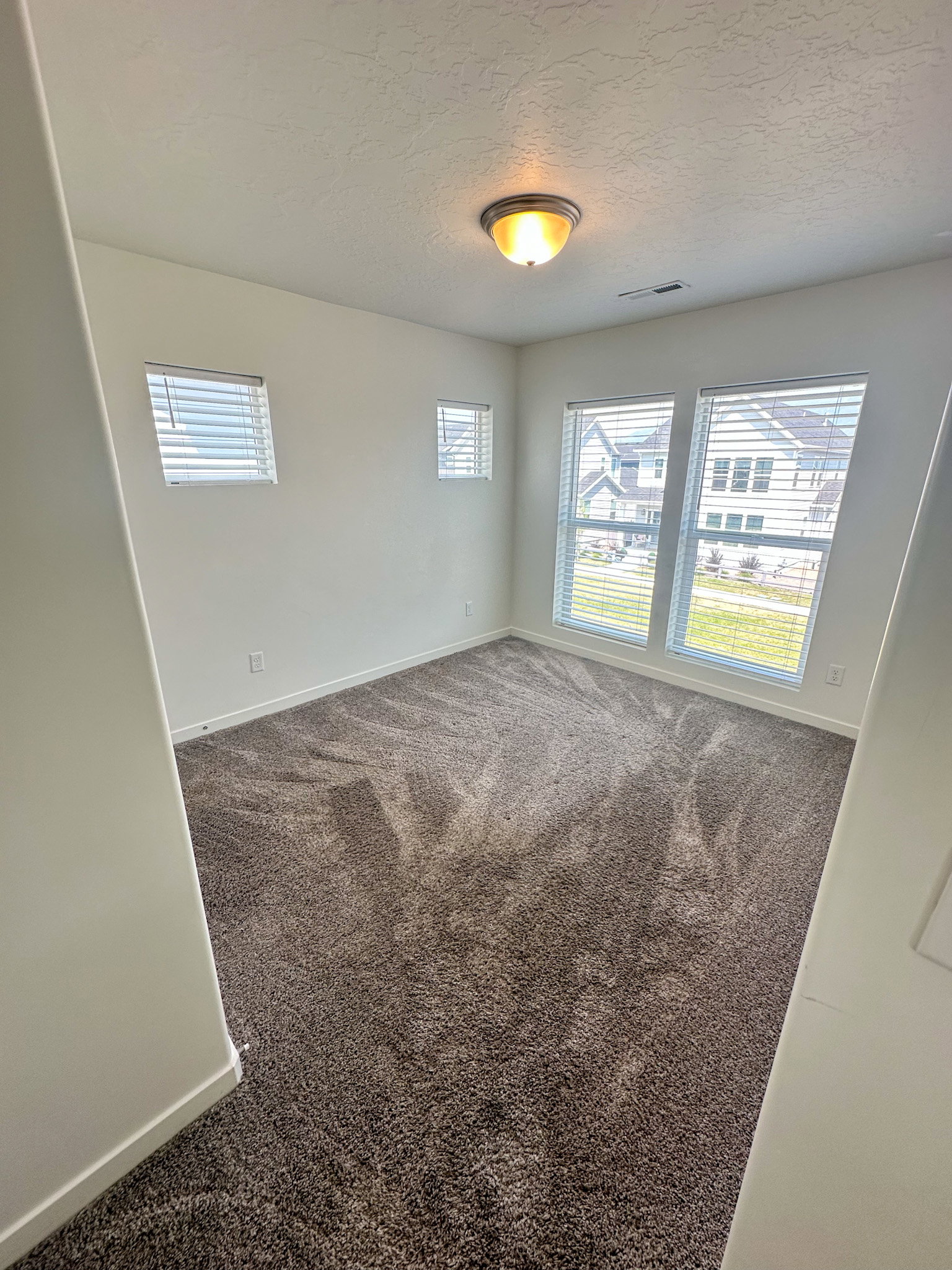 Unfurnished room featuring dark carpet and a textured ceiling
