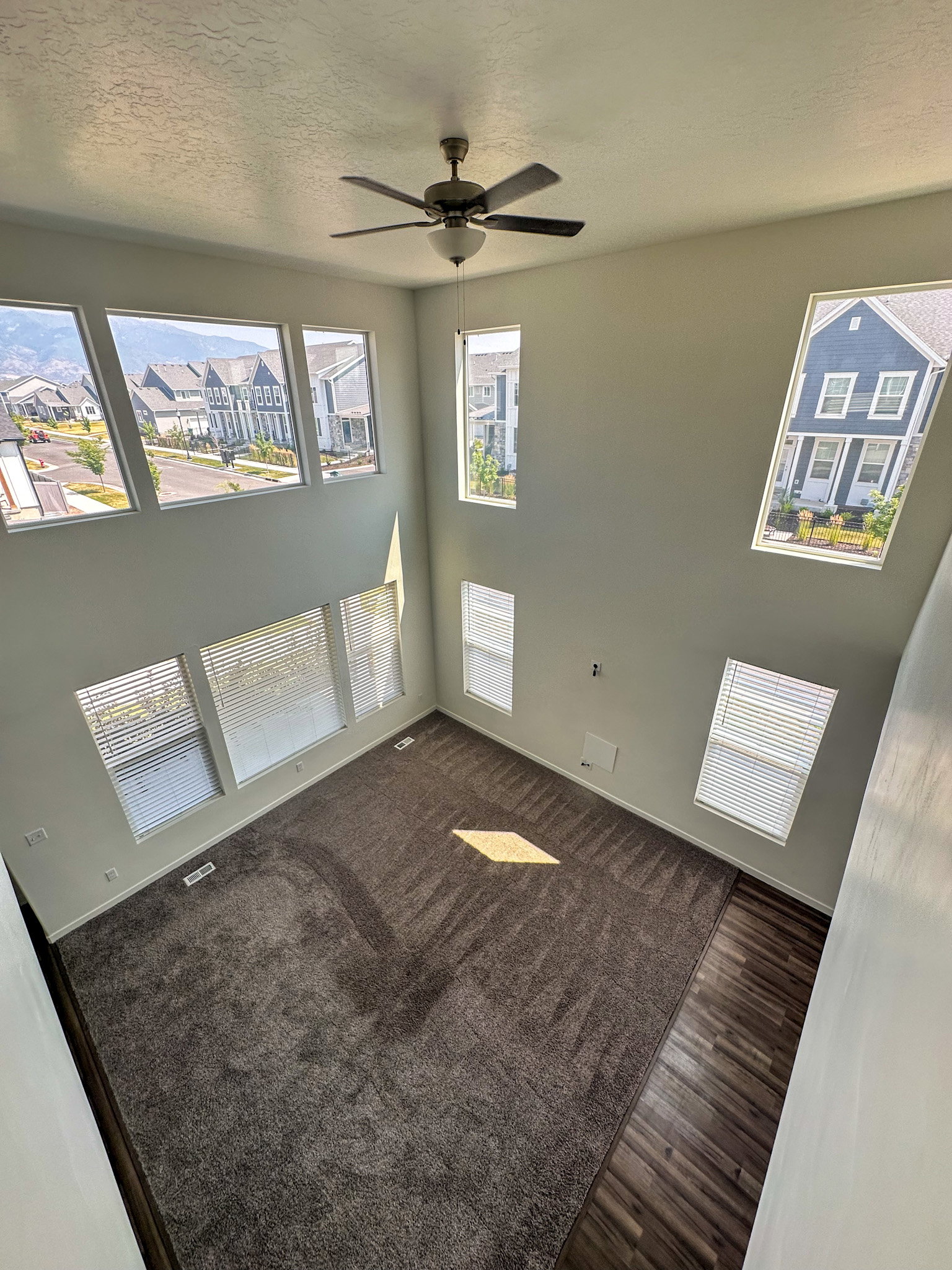 Empty room with a ceiling fan, a textured ceiling, and dark wood-style floors